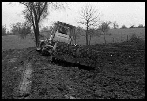 A tractor preparing land for lagoon construction.