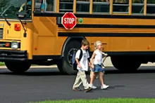 Two children walking away from school bus